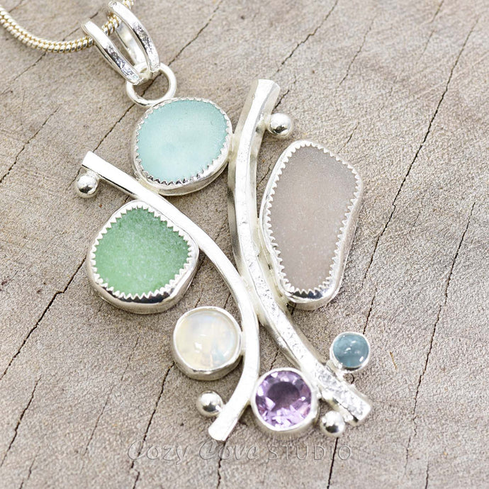Sea glass statement pendant necklace in a hand crafted setting of tarnish resistant sterling silver accented with semi-precious gemstones. (N608)
