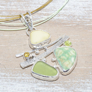 Sea glass and vitreous enamel pendant necklace in a hand crafted setting of sterling silver accented with semi-precious gemstones. (N619)