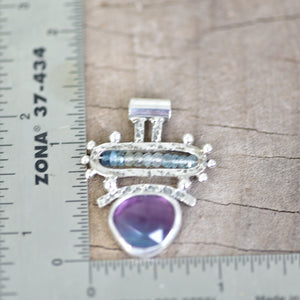 Handcrafted bicolor purple and blue fluorite pendant accented with microfaceted beads of aquamarine in a sterling silver setting. (N736)
