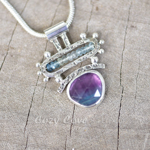 Handcrafted bicolor purple and blue fluorite pendant accented with microfaceted beads of aquamarine in a sterling silver setting. (N736)