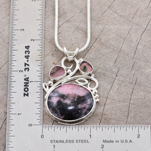 Gemstone necklace with a pink and gray rhodochrosite cabochon and bicolor tourmaline slices in an handcrafted setting of sterling silver. (N737)