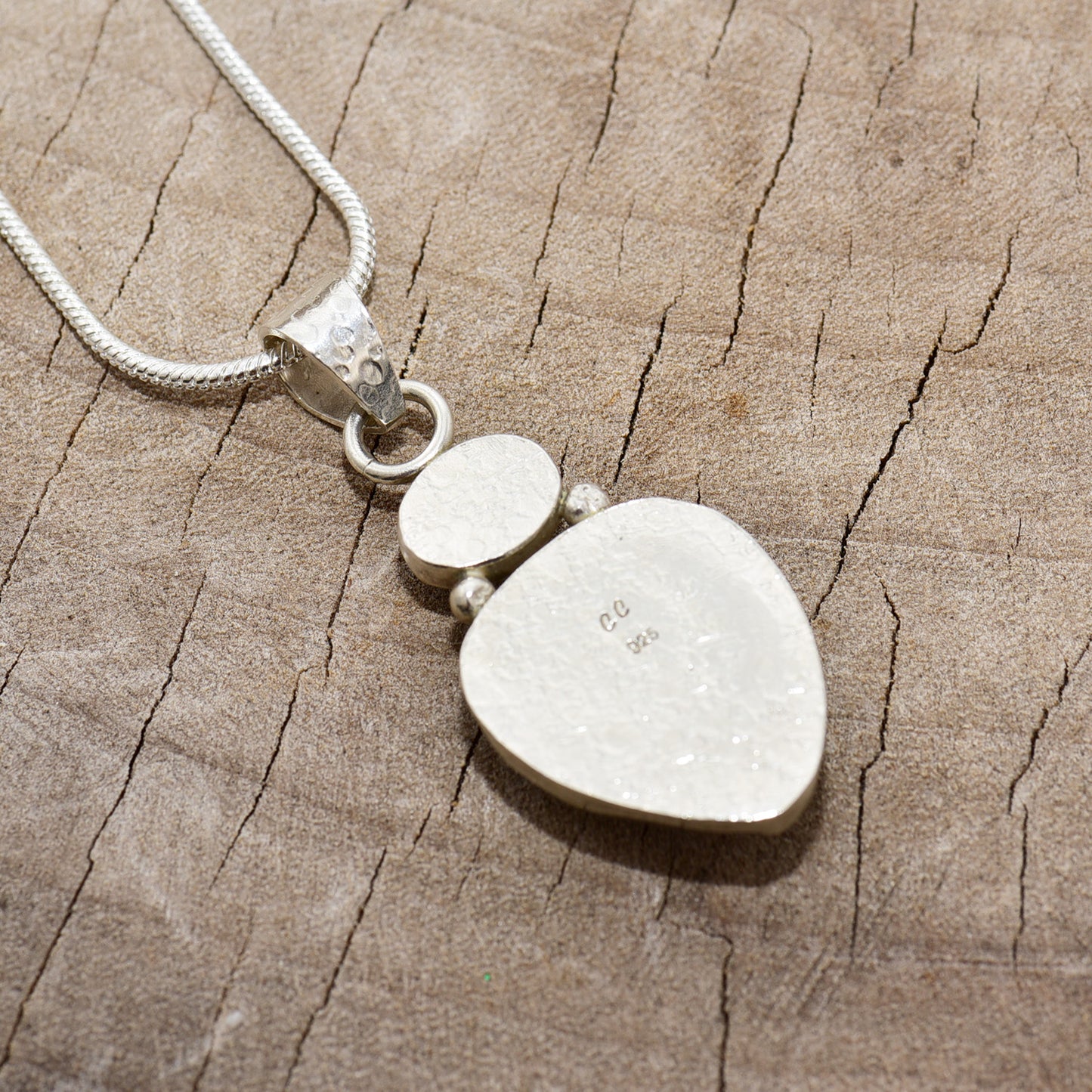 Pendant necklace with hand made enamel cabochon in shades of blue in a setting of sterling silver. (N764)
