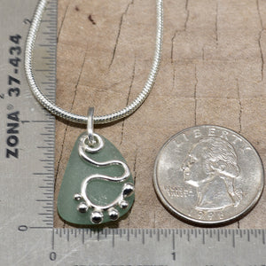 Sea glass pendant necklace accented with a handcrafted sterling silver charm. (N814)
