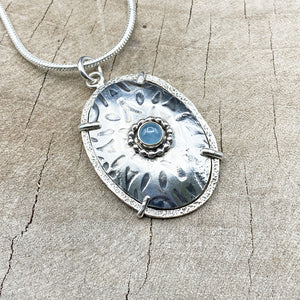 Framed sterling silver pendant necklace accented with an aquamarine cabochon. (N826)