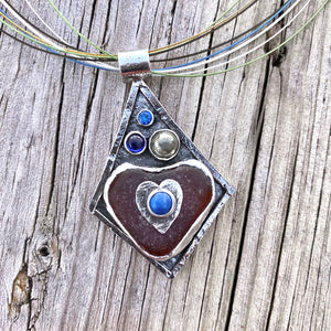 Sea glass pendant necklace in a hand crafted setting of sterling silver accented with semi-precious gemstones.(N572)