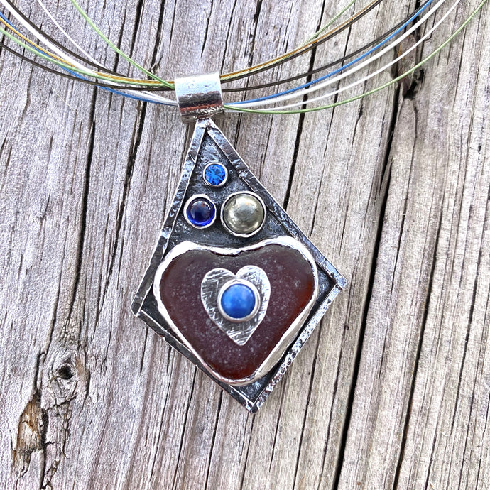 Sea glass pendant necklace in a hand crafted setting of sterling silver accented with semi-precious gemstones.(N572)